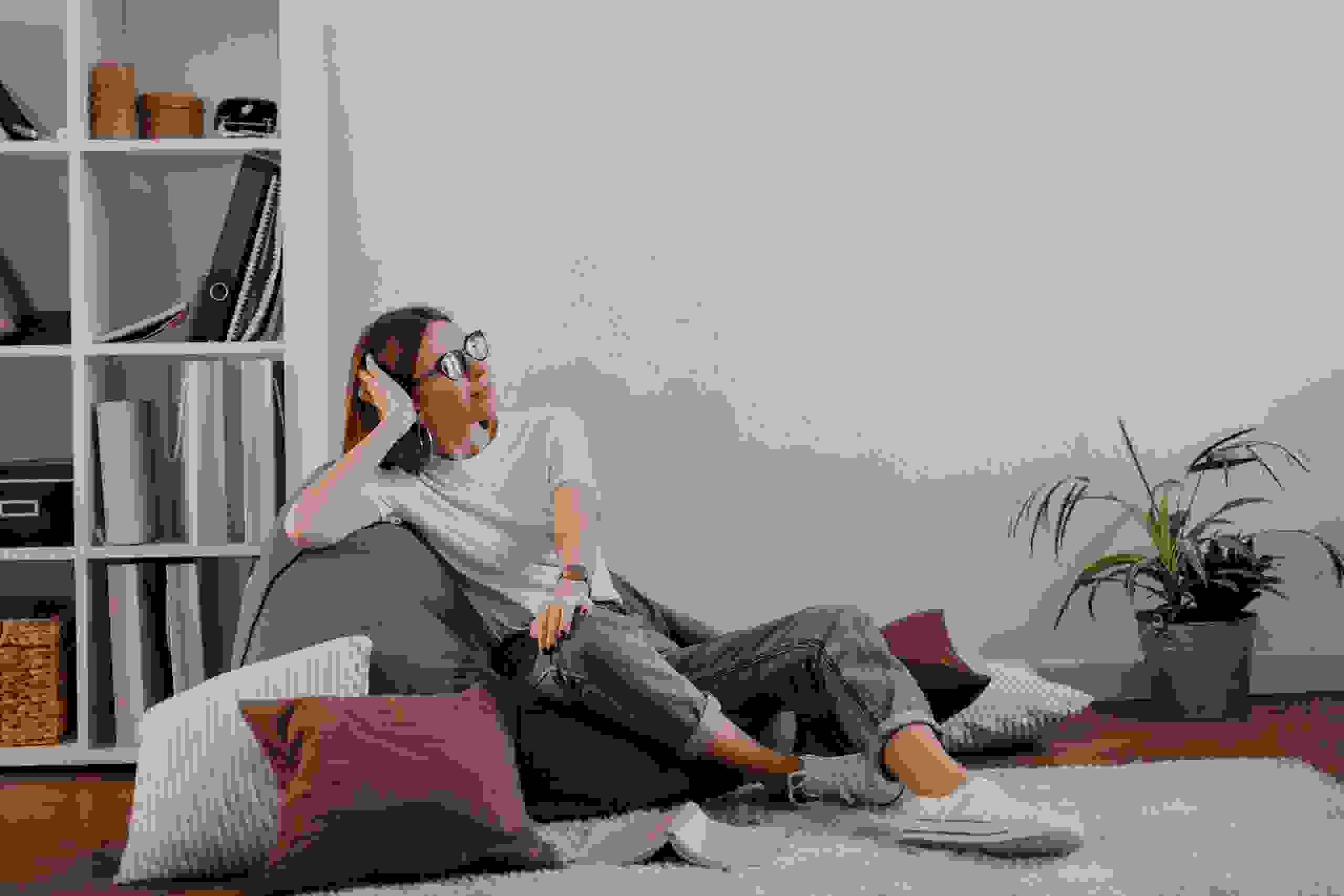 satisfied-woman-jeans-t-shirt-relaxed-sitting-bag-chair-against-shelf-with-folders.jpg